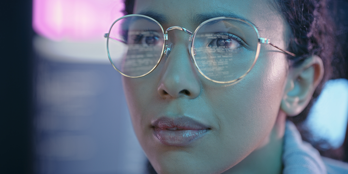Woman with glasses looking at screen.