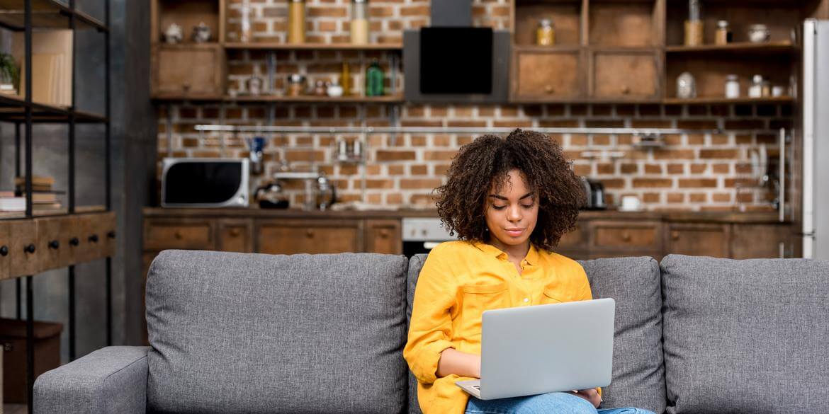 Woman on sofa with laptop on lap