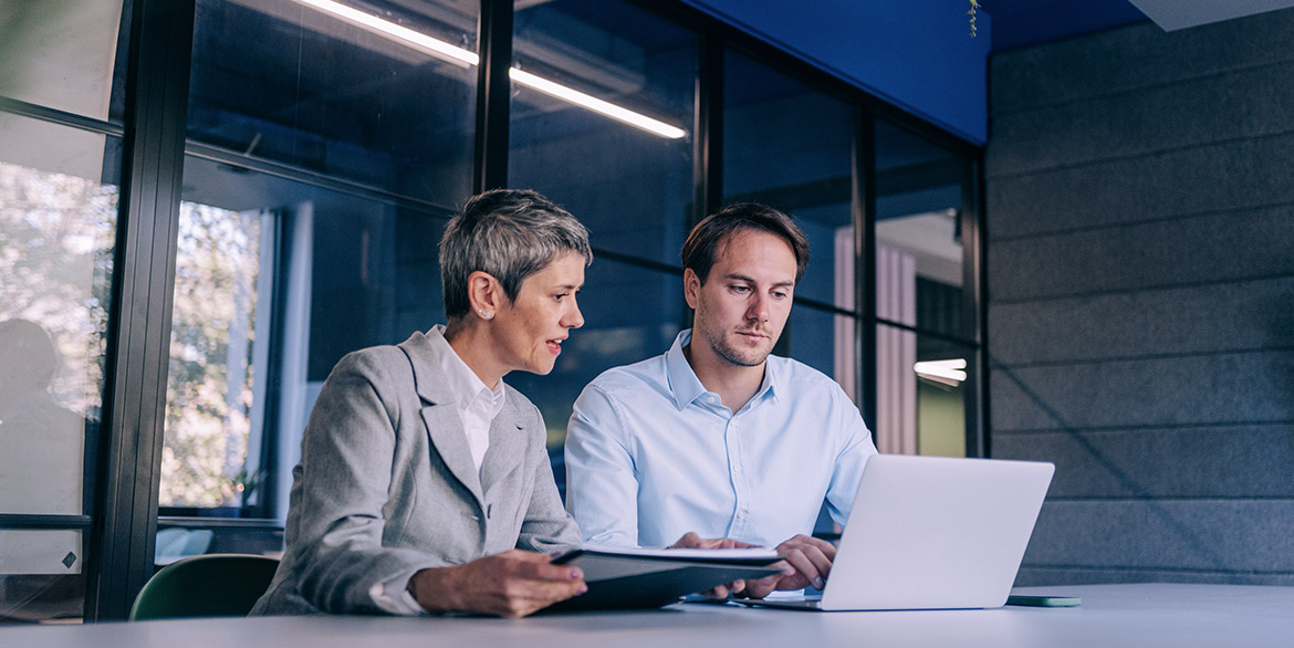 Two people - male and female - looking at a laptop.
