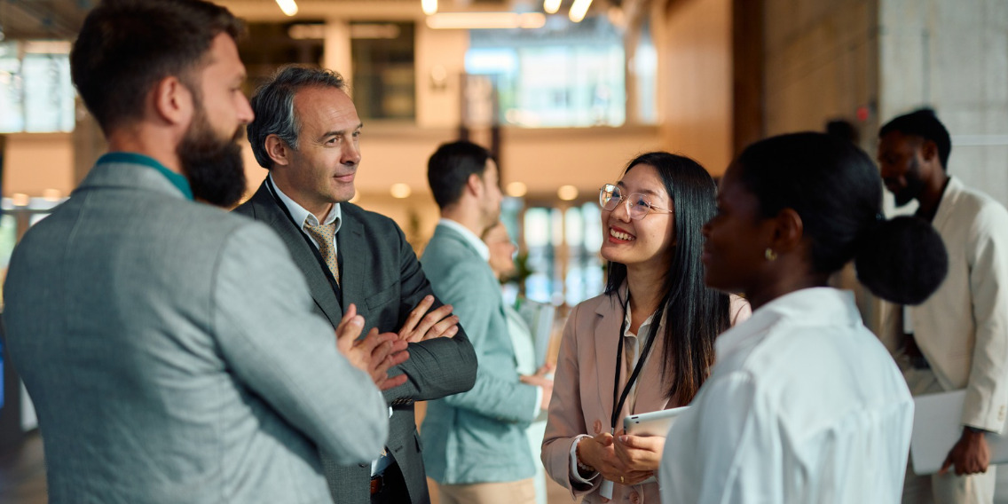 People in an office environment standing up and talking.