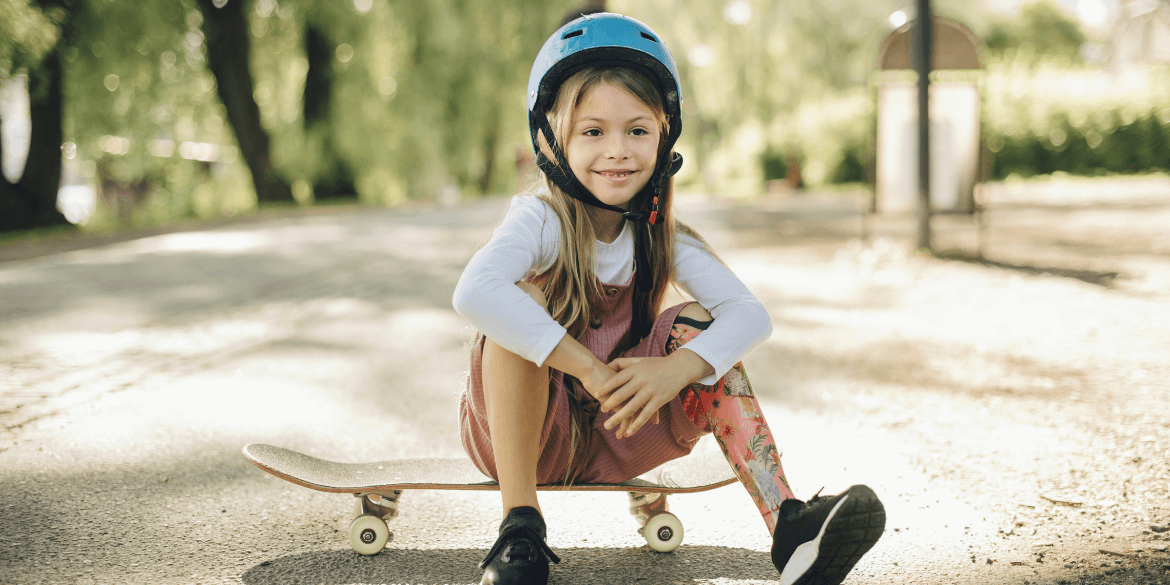 Child sitting on skateboard.