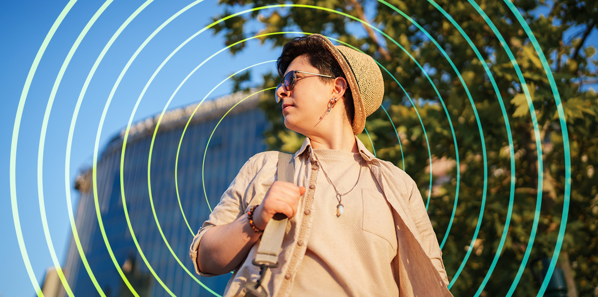 Woman with bag looking over her shoulder on a sunny day.