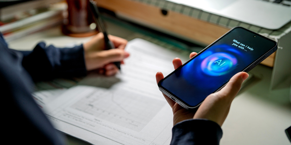 Person's hand holding mobile phone with AI written on it.
