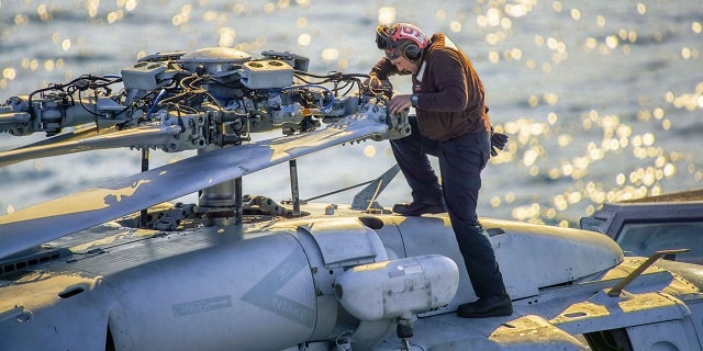 Sailor works on a helicopter