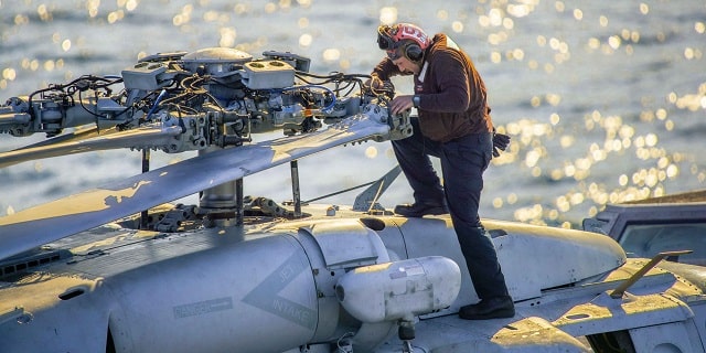 Sailor works on a helicopter 