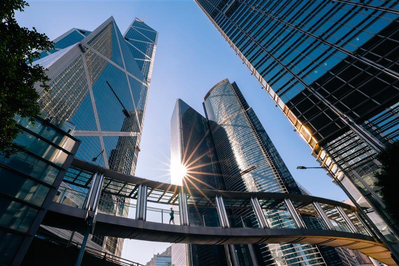 Skyscrapers viewed from the bottom up with a blue sky visible.